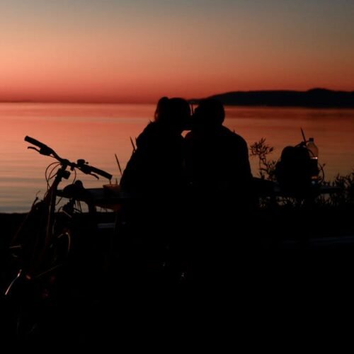 Beach Scenery - Silhouetted couple kissing by the beach at sunse #12591286
