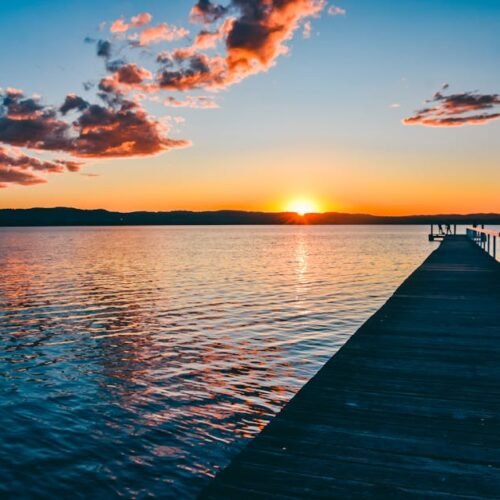 Beach Scenery - A peaceful sunset over a calm lake with a long w #16354041