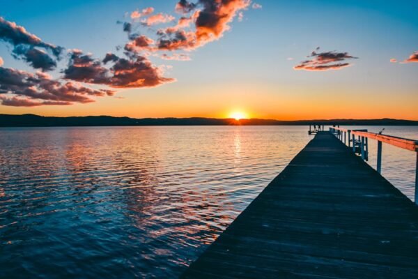 Beach Scenery - A peaceful sunset over a calm lake with a long w #16354041