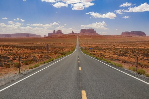 Desert Wilderness - A long, empty highway stretches through Monument #18514240