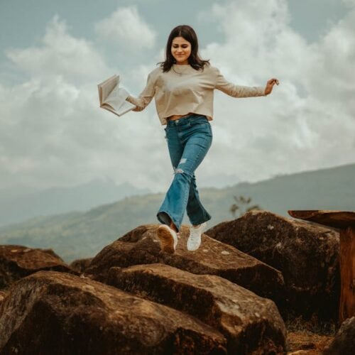Mountain Landscapes - A young woman joyfully leaps over rocks in the s #20835918