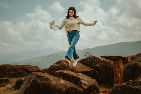 Mountain Landscapes - A young woman joyfully leaps over rocks in the s #20835918