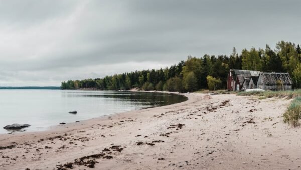 Beach Scenery - Tranquil sandy beach with rustic boat houses ami #29624644
