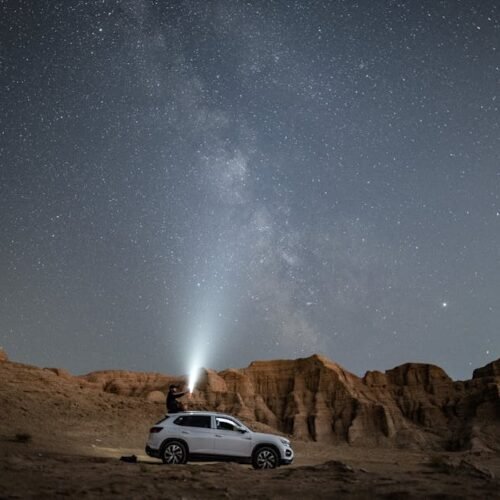 Desert Wilderness - A person stands on an SUV under a vast starry ni #3064258 Desert Wilderness - A person stands on an SUV under a vast starry ni #3064258