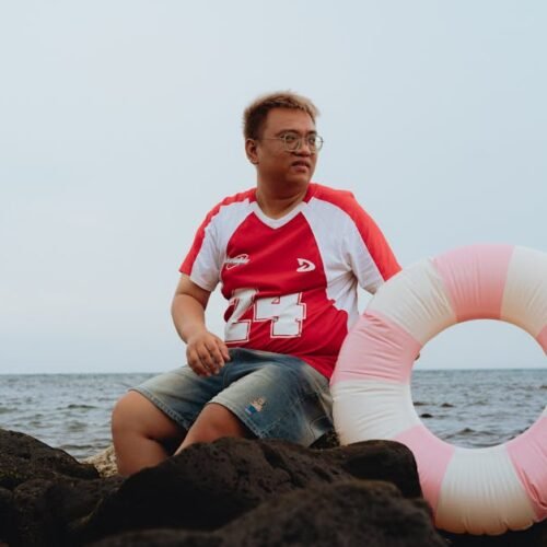 Beach Scenery - Casual moment of a man sitting on rocks by the s #31621038