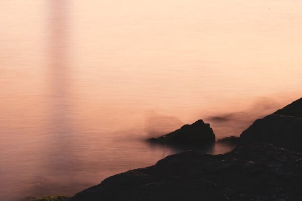 Desert Wilderness - Soft focus image of rocks by the calm sea at sun #32903576
