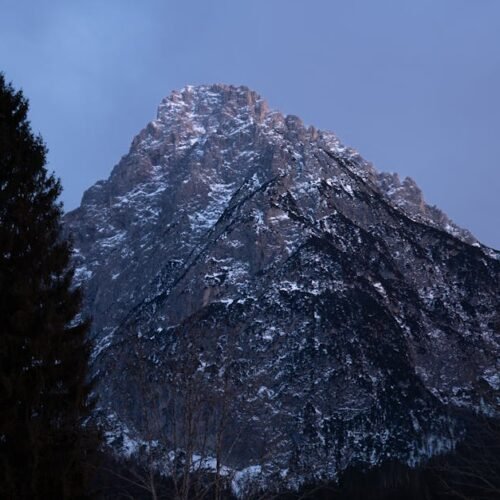 Snow Mountains - Majestic snow-capped mountain with dark trees ca #36211322