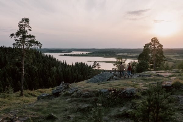 Lake Reflections - A couple enjoys a serene walk on a rocky cliff o #6317945